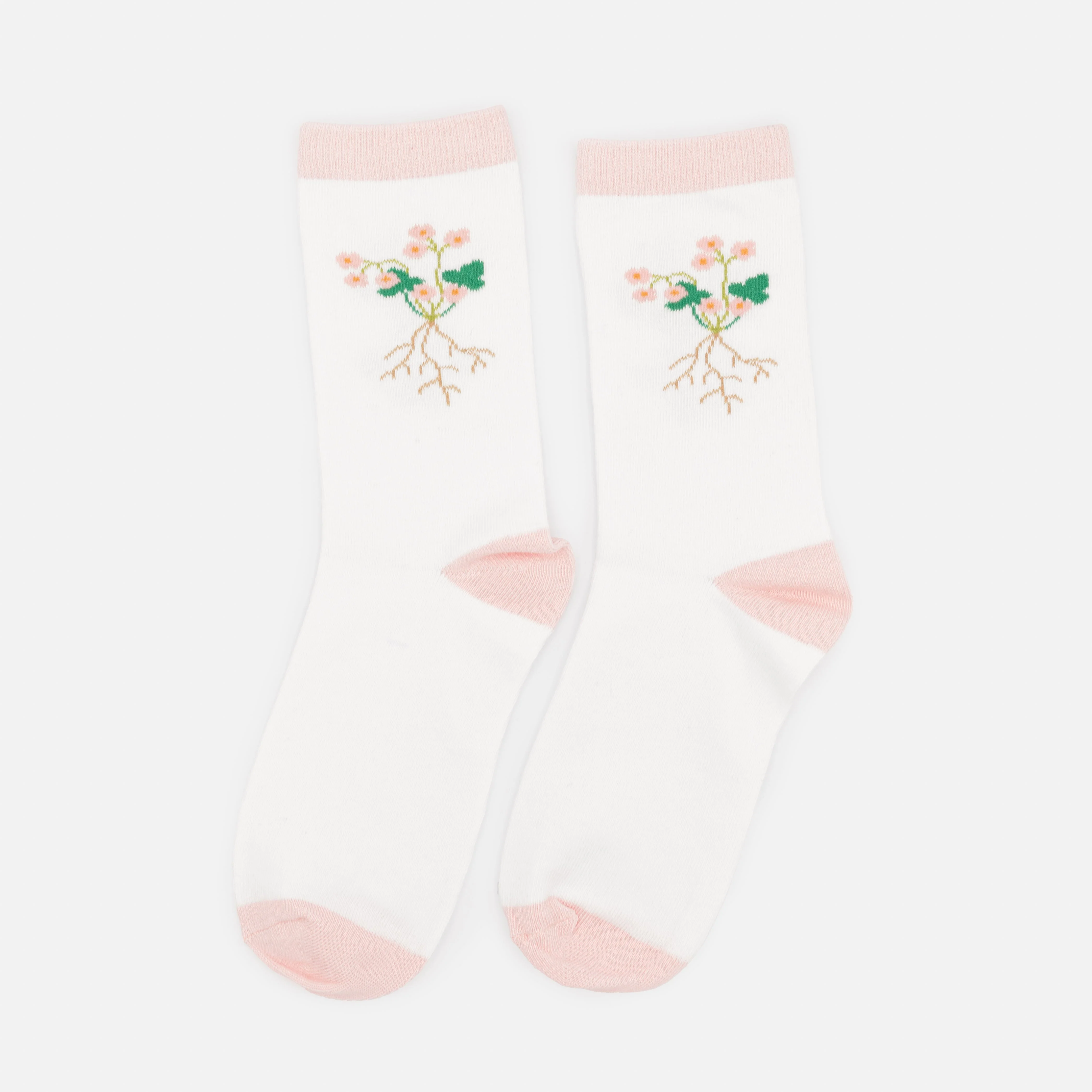 Bas blancs et rose pâle avec racines de fleurs