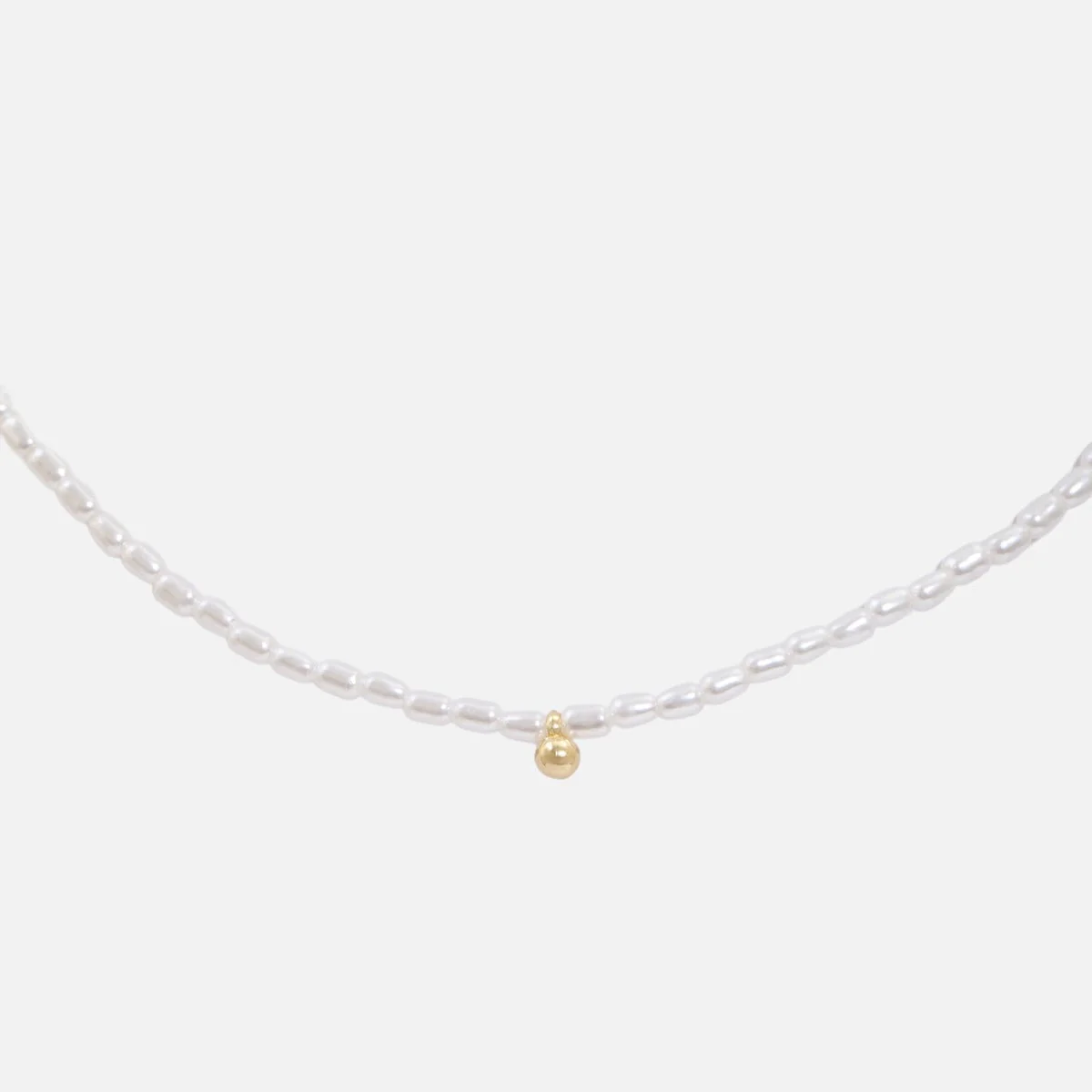 Collier perles synthétiques et breloque boule dorée